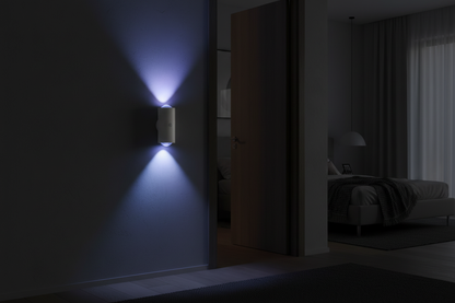 Single white cylindrical motion night light glowing colour-changing blue-purple beside bedroom door