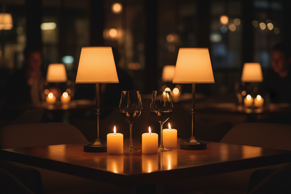 Pair of black cordless table lamps glowing warm on restaurant dining table