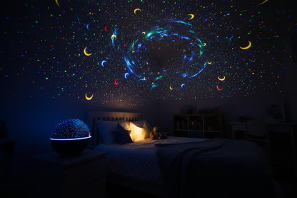 Round blue dome 360° galaxy projector on bedside table projecting multicolour stars and moon across kids bedroom ceiling