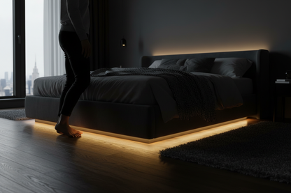 Motion sensor LED strip light glowing warm white under bed frame automatically illuminating bedroom floor at night