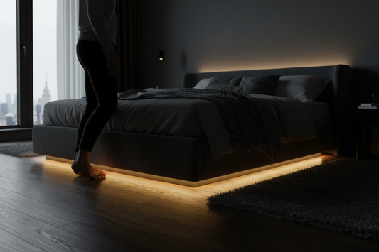 Motion sensor LED strip light glowing warm white under bed frame automatically illuminating bedroom floor at night